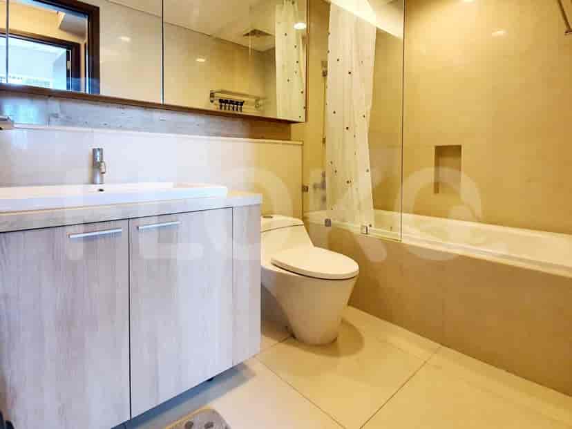 A modern bathroom with a vanity, toilet, and a bathtub with a shower.