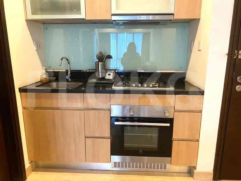 A modern kitchen with wooden cabinetry, gas stove, and stainless steel appliances.