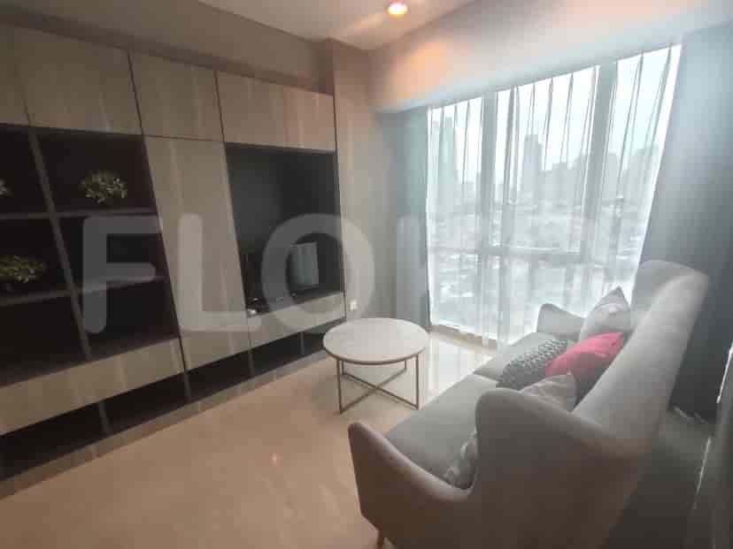 Modern living room featuring a grey sofa, entertainment unit, and city views.
