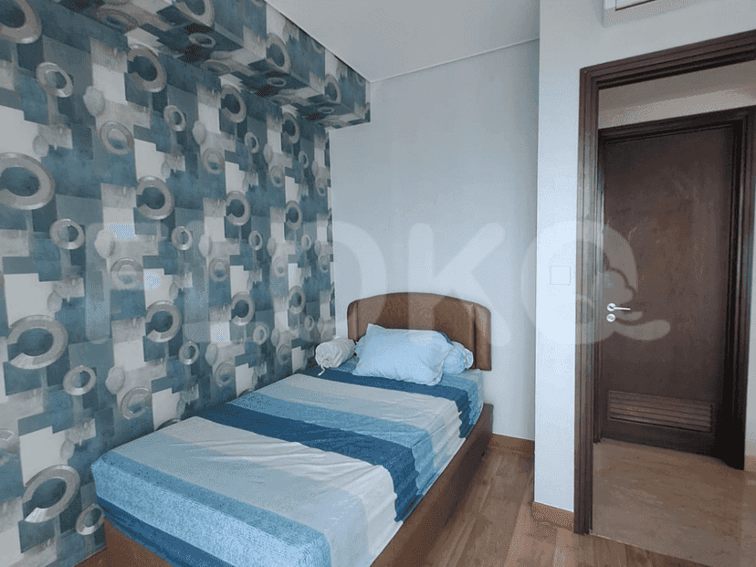 Small bedroom with a bed and patterned wallpaper.