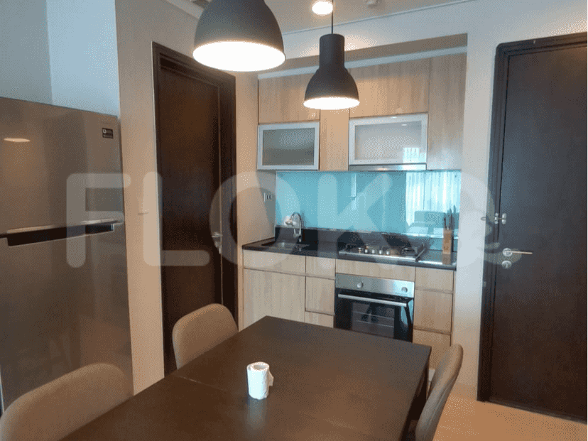 Modern kitchen with dining area, featuring wooden cabinets, and a dark brown table.