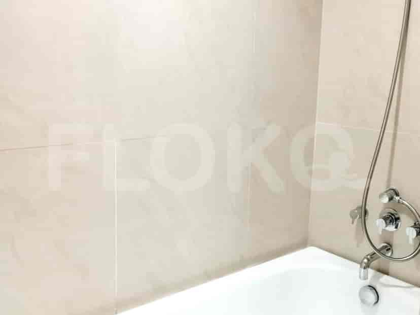 A modern bathroom with a bathtub and beige tiles.