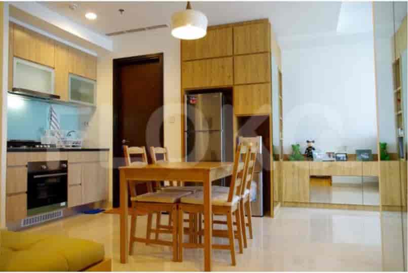 Dapur modern dengan lemari kayu, meja makan, dan kulkas.