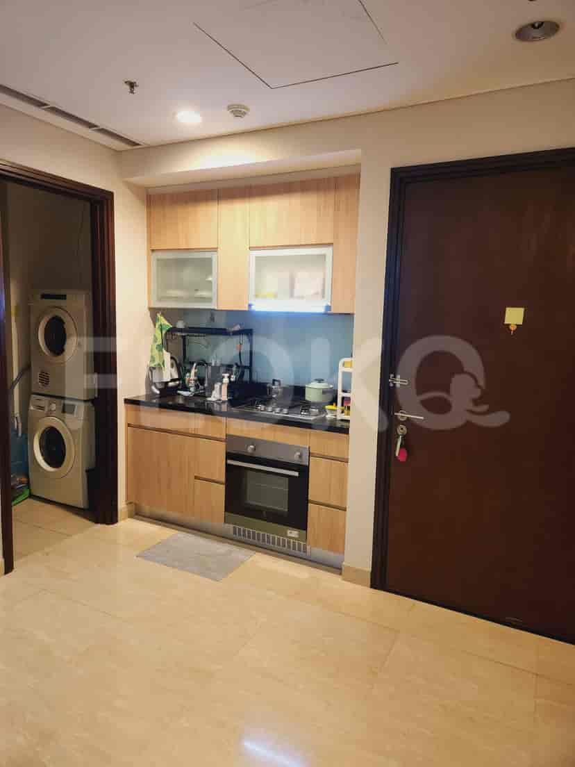A modern kitchen with wooden cabinets, built-in appliances, and a compact layout.