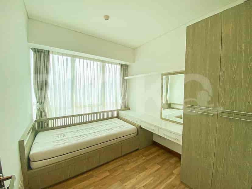 A second bedroom with a bed and large windows.