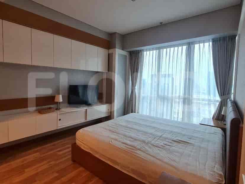 Bedroom with large windows, a bed, and built-in storage.