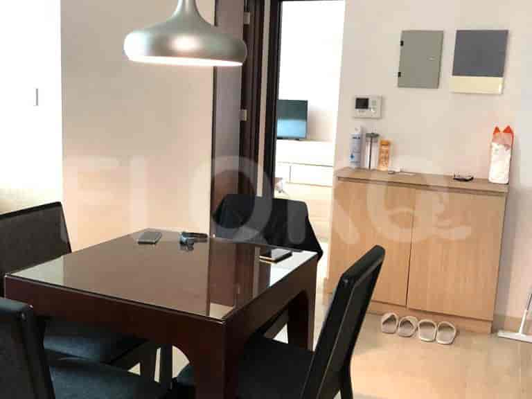 Dining area with a table, chairs, and a hanging light fixture.