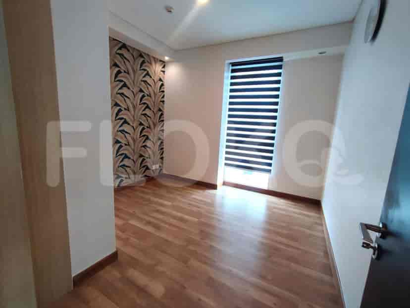 A small bedroom with a bed and a window.