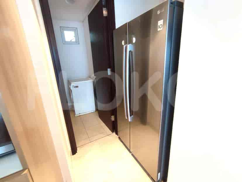 A view from the kitchen to the washing machine and refrigerator.