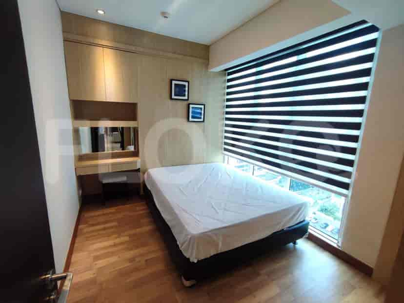 A small bedroom with a double bed, a built-in wardrobe and a window with blinds.