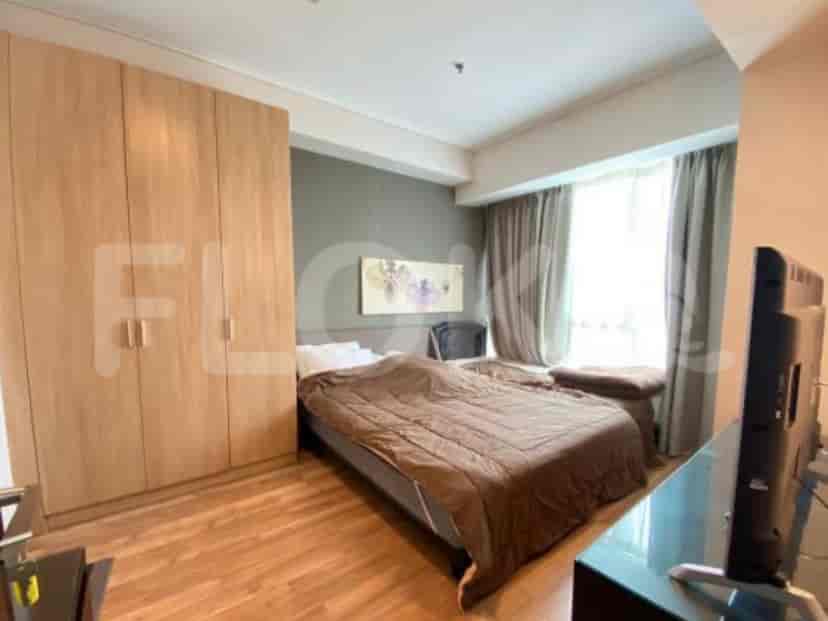 Bedroom with a bed, closet, and TV.