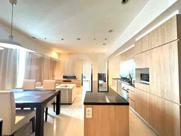 An open-plan living, kitchen, and dining area with wooden cabinetry, a dining table, and a kitchen island.