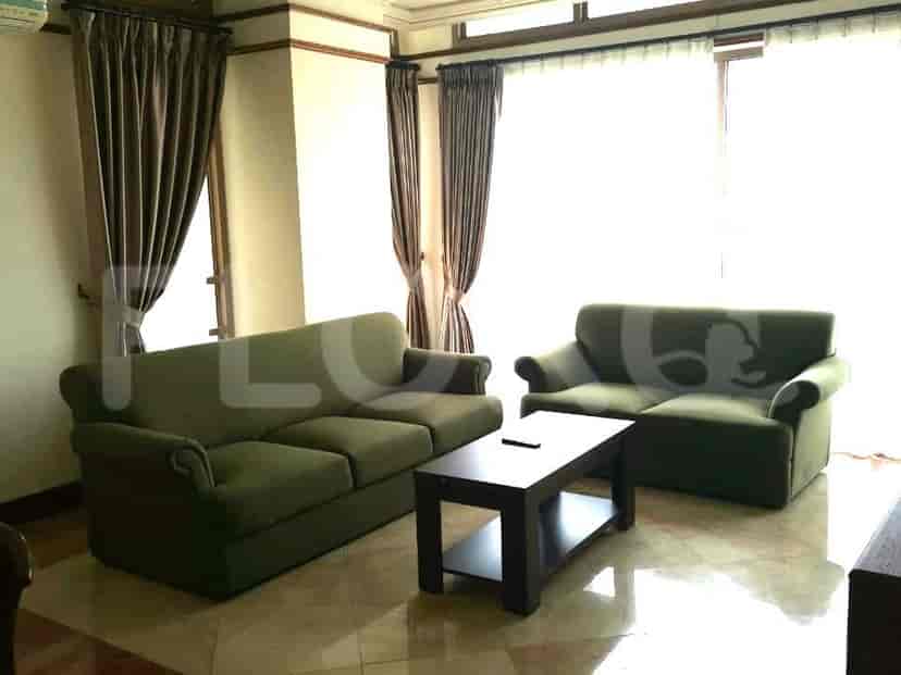 Living room with green sofas, coffee table, and marble floor.