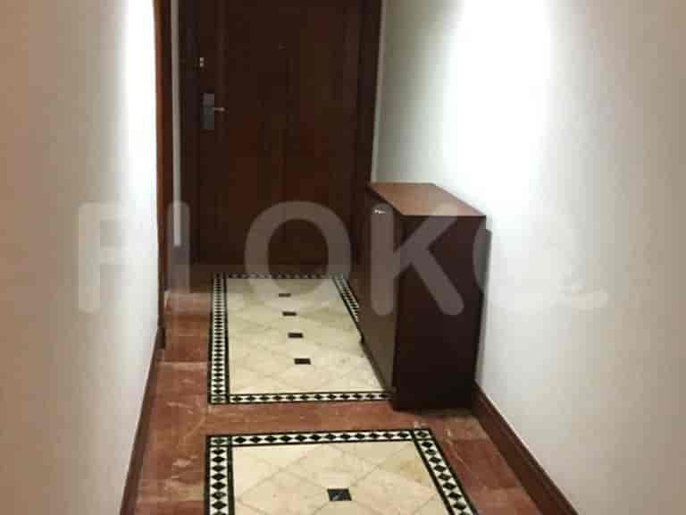 A hallway with a cabinet and door.