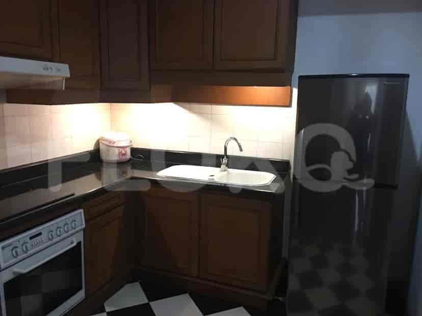 A kitchen with cabinets, a sink, and a refrigerator.