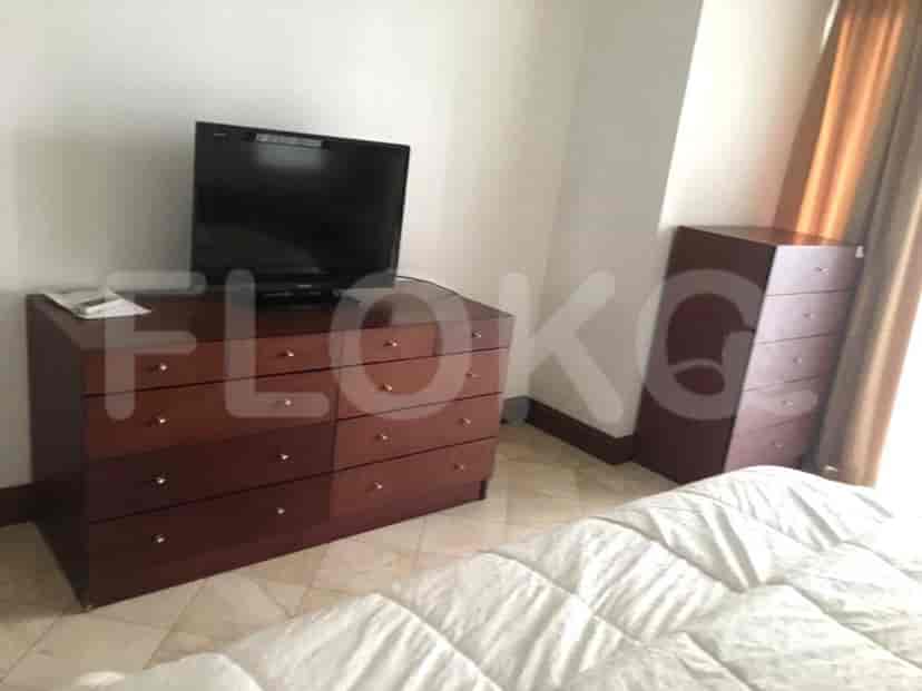 A bedroom with a TV, dresser, and a cabinet.