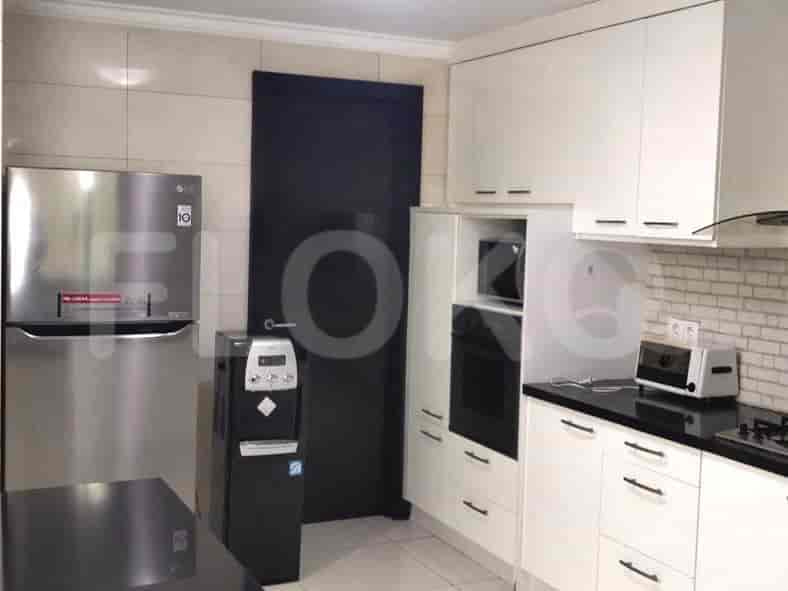 A modern kitchen with white cabinets, stainless steel appliances, and a black countertop.