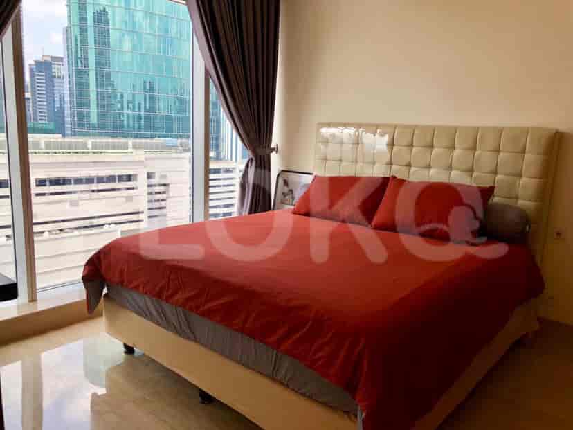 Bedroom with bed, curtains, and a city view.