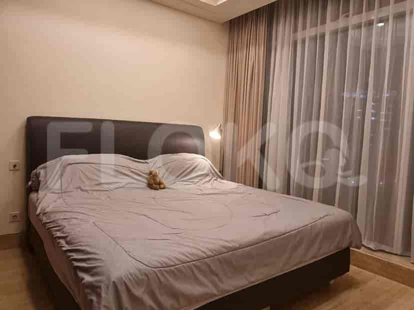 A bedroom with a large bed and sheer curtains.