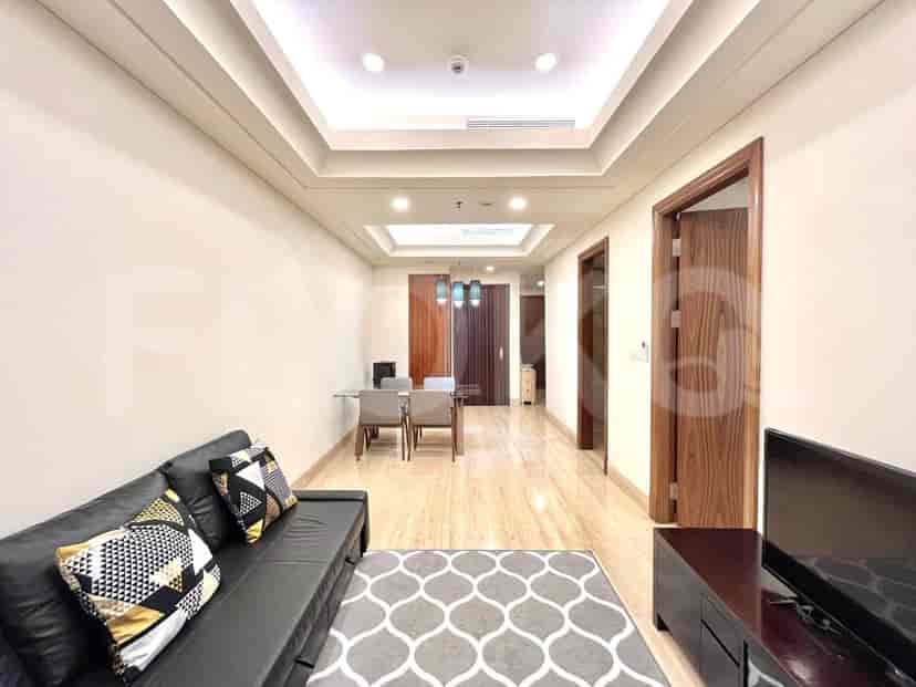 Spacious living room with a black sofa, dining table, and TV.