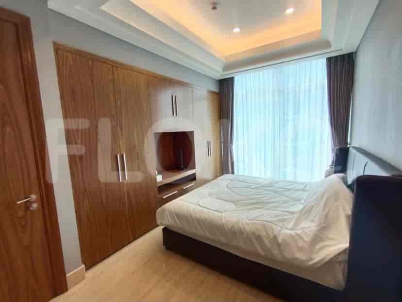A modern bedroom with a wooden wardrobe, large window, and a comfortable bed.
