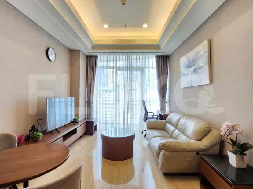 A modern living room with a sofa, TV, and round coffee table.