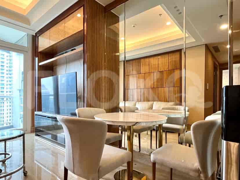 Dining area with round marble table and chairs, reflection in a mirror.