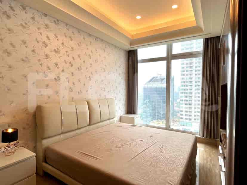 Bedroom with a large bed, nightstands, and a view of the city.