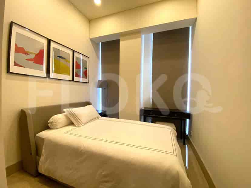 A bedroom with a bed, artwork, and a desk.