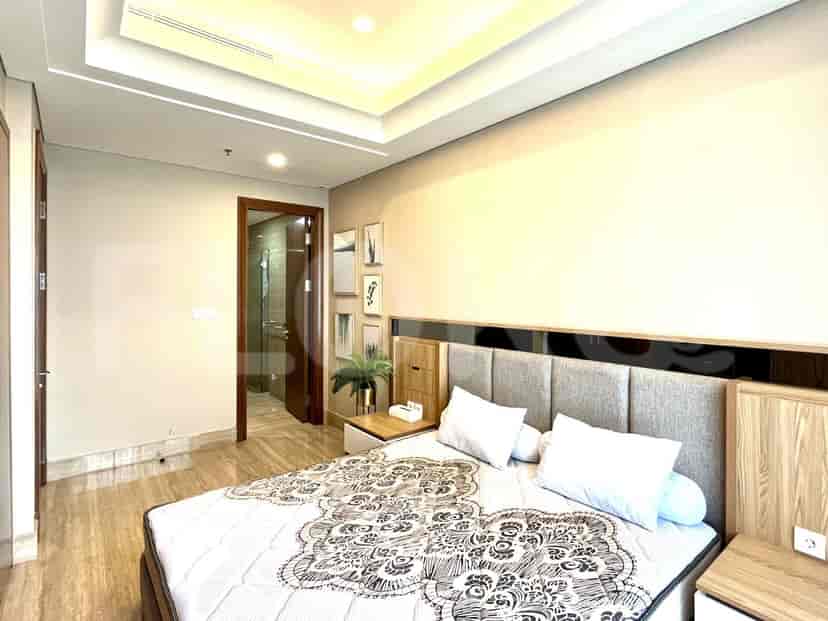 A bedroom with a bed, artwork, and a door leading to a bathroom.