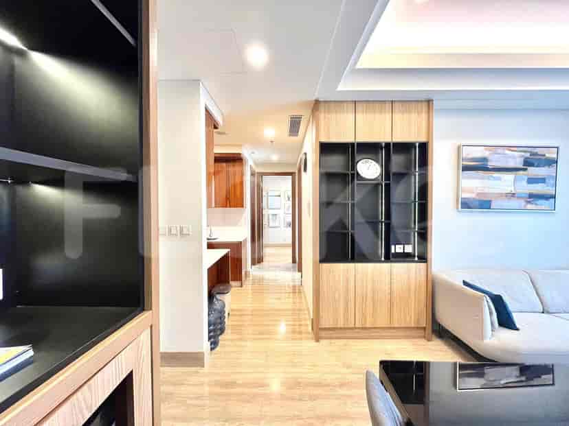 Hallway with wooden paneling, artwork, and black shelves.