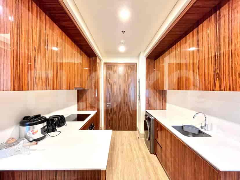Modern kitchen with wooden cabinets, white countertops, and a washing machine.