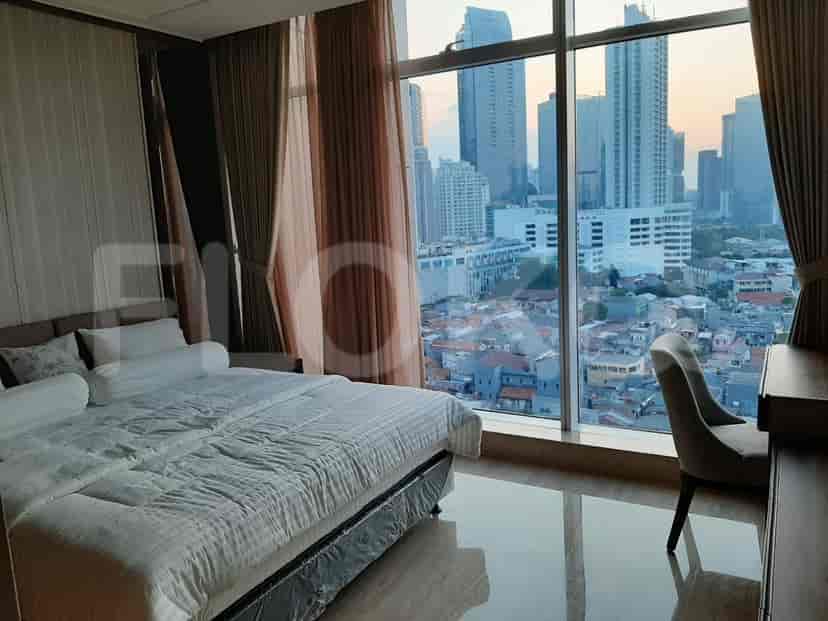 A stylish bedroom with a large window offering a stunning city view.