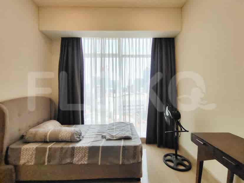 A bedroom with a bed, wardrobe, and large windows.