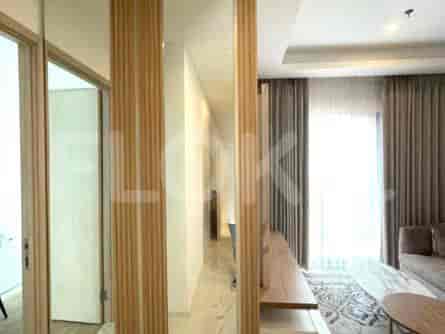 A corridor with mirrored accents and a doorway to a room.