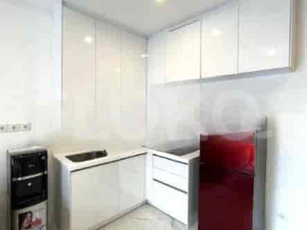 A small kitchen area with white cabinets and a red refrigerator.