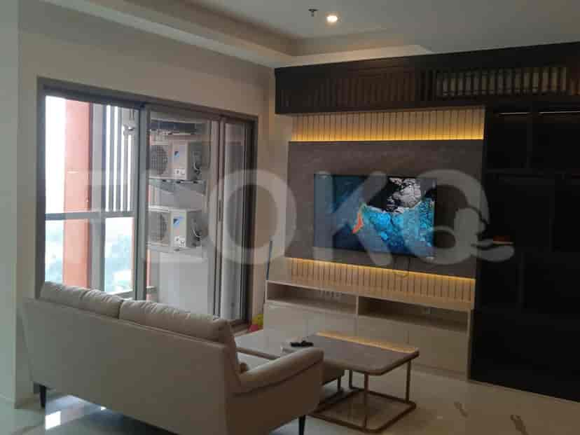 Contemporary living room featuring a sofa, TV, and integrated cabinetry.