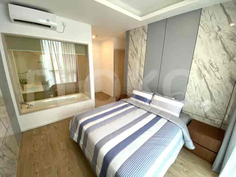 Bedroom with a king-size bed, marble wall accent, and ensuite bathroom.