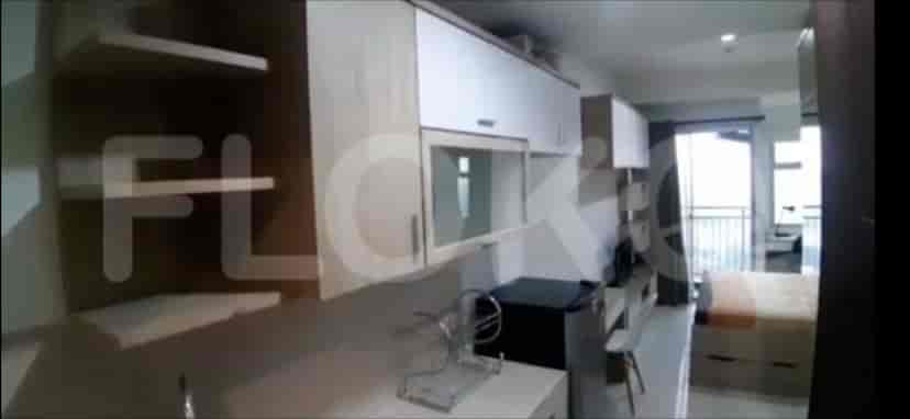 A compact kitchen with cabinets, a sink, and a small refrigerator.