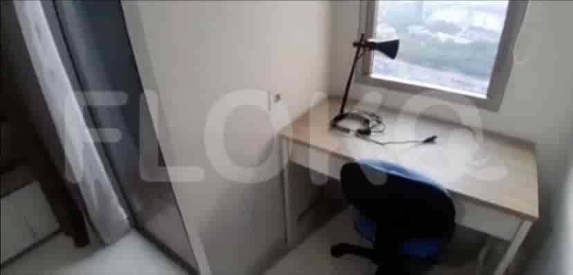 A desk area with a lamp and chair.