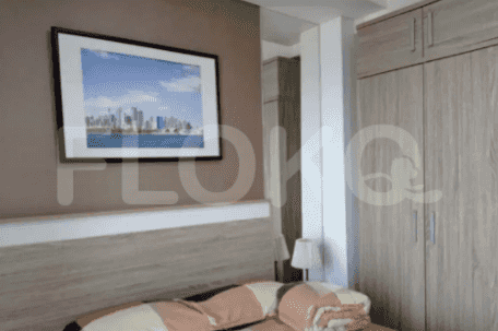 A bedroom with a large bed, a framed picture, and a closet.