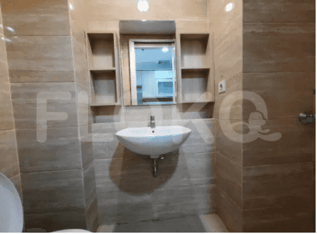 A modern bathroom featuring a sink and mirror, with a light beige tile.