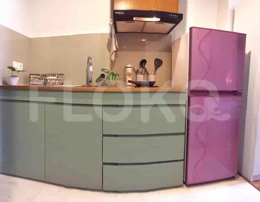 A modern kitchen with wooden counters and pink refrigerator.