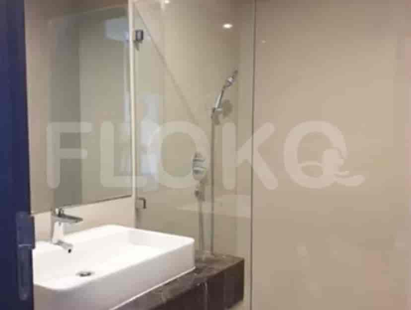 A modern bathroom with a glass shower and white sink.