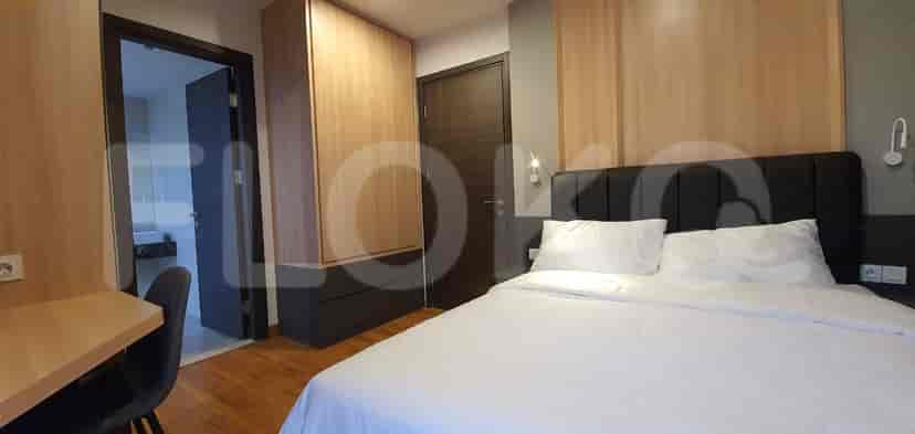 Bedroom with a double bed, wooden paneling, and a bedside cabinet.