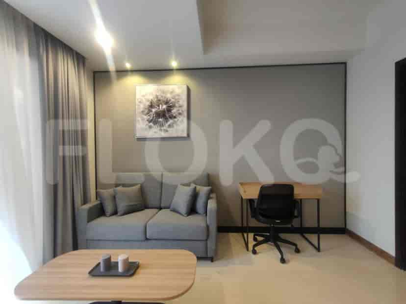 Living room with a small desk, sofa and art.