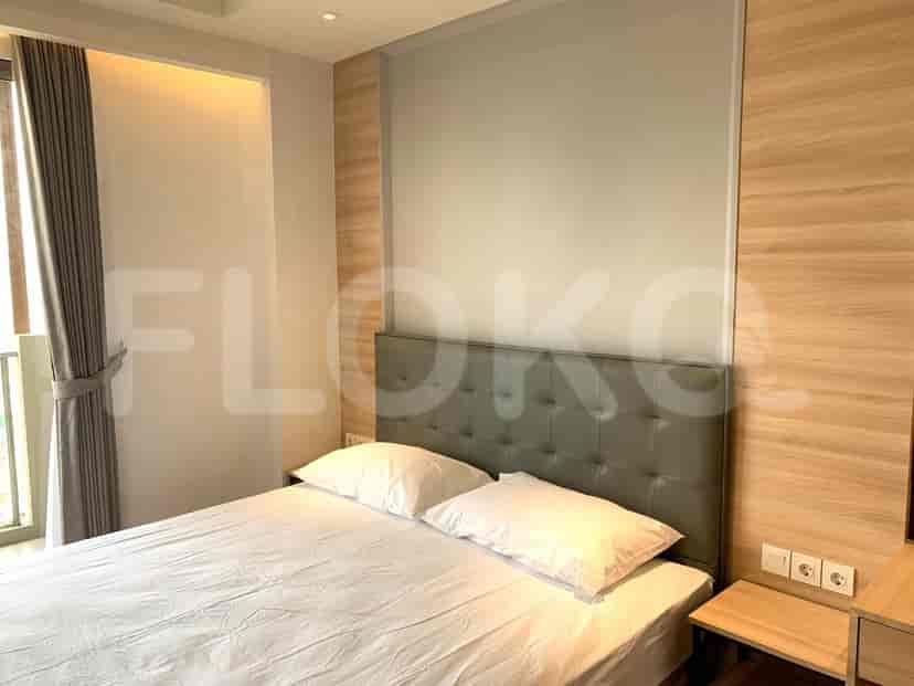 Kamar tidur dengan tempat tidur ganda, meja samping tempat tidur, dan meja rias.