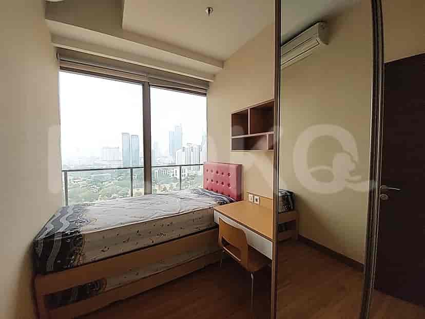 Kamar tidur ringkas yang menampilkan tempat tidur single, meja, dan pemandangan kota.