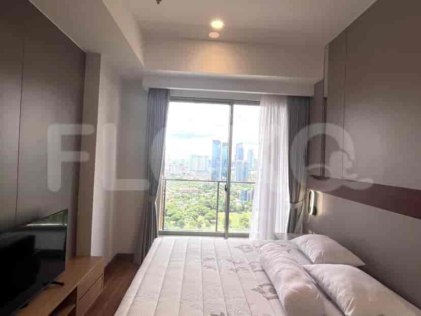 Kamar tidur dengan jendela besar yang menawarkan pemandangan kota, bersama dengan tempat tidur dan meja rias.
