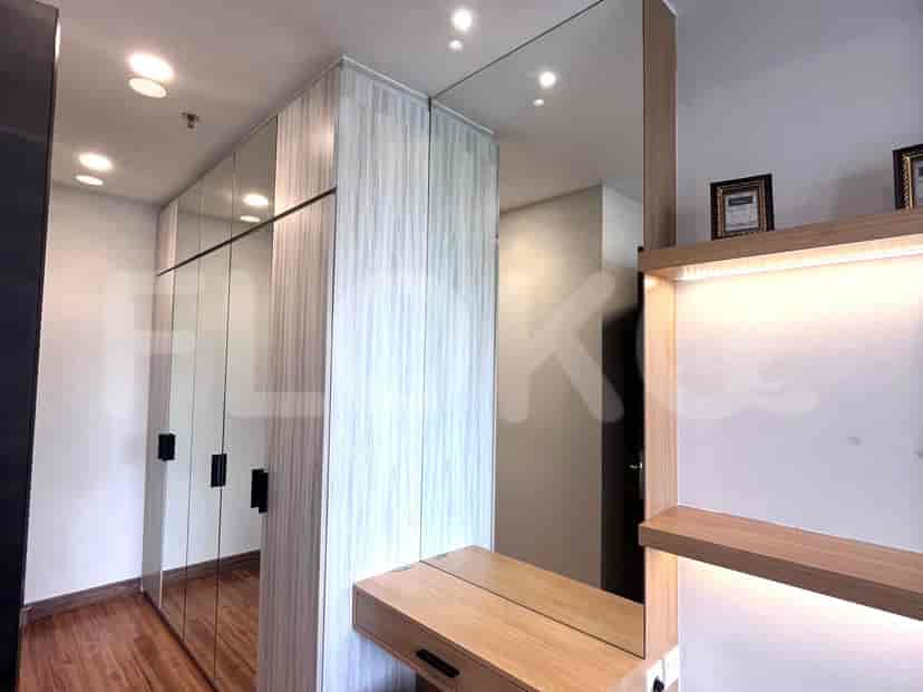 Area lemari dan meja rias yang bergaya dengan pintu bercermin besar dan elemen kayu.